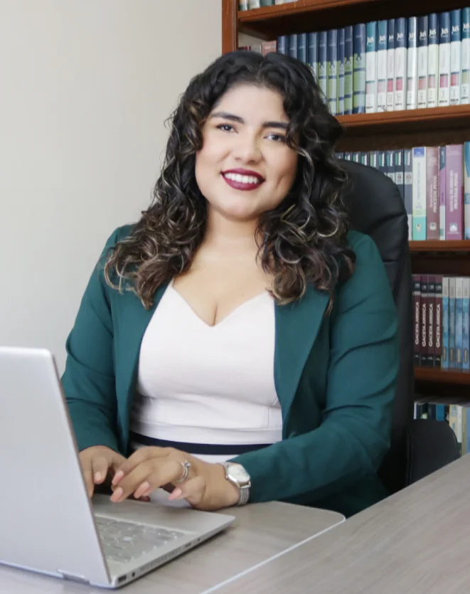 meliza-mogollon-sentada-en-un-escritorio-sonriendo